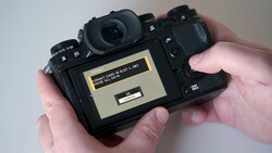 Photographer's hands holding a mirrorless camera displaying a memory card error message on the rear LCD screen.