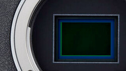 Camera sensor with blue and green color filter array pattern visible through open aperture.