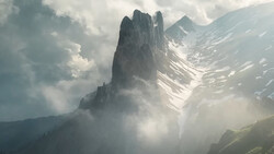 Dramatic mountain peak shrouded in mist with forested slopes and snow-capped ridges beneath cloudy sky.
