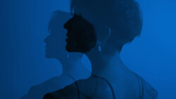 Multiple silhouetted profiles of a woman's face and shoulders overlaid against a deep blue background.