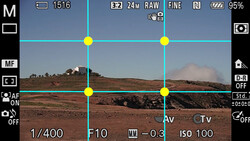 Screenshot of camera viewfinder showing composition grid overlay on arid landscape with distant hills.