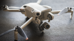 DJI Mavic 3 drone positioned on gray textured surface with propellers extended.