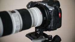 Canon EOS R5 mirrorless camera mounted on tripod with white telephoto lens attached.