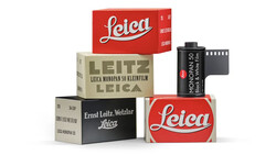 Stacked vintage Leica film camera boxes and film canisters arranged in a pyramid composition.