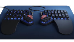 Ergonomic split mechanical keyboard with illuminated keys and matching mouse on dark mousepad.