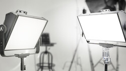Two panel LED studio lights mounted on stands in a professional photography setup.