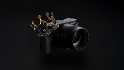 Sony mirrorless camera with ornate gold crown prop on black background.