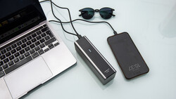 Laptop, two portable power banks, and sunglasses arranged on a white surface.