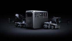 Portable power station surrounded by professional drones and cameras against a dark background.