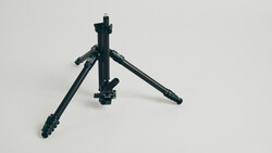 Black tripod with extended legs and center column against white background.