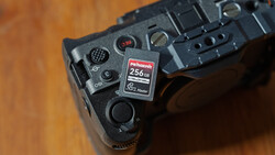 Close-up of camera grip showing memory card slot with 256GB Rekordth card inserted.