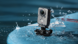 Action camera mounted on a blue surface with water splashing around it during a water sports activity.