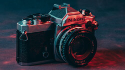 Red and black Nikon FM2 camera with Series E lens against moody red and teal gradient background.