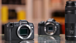 Canon EOS R5 mirrorless camera body with Canon 75-300mm telephoto lens displayed on reflective surface.