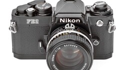 Nikon FE2 film camera with standard 50mm lens mounted, shot from front against white background.