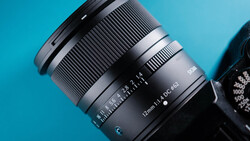 Telephoto zoom lens with focal length markings visible against a bright blue background.
