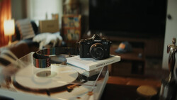 Nikon camera displayed on stacked books atop a round table in a creative workspace.