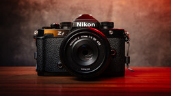 Nikon Zf mirrorless camera with black textured body and mounted 40mm lens on wooden surface.