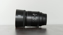 Sirui 85mm F1.4 lens with hood mounted, displayed on light gray surface.