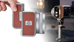 Vintage compact camera with red leather exterior and silver metal trim, held in hand against blurred background.