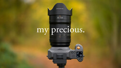 Hasselblad 35-100mm zoom lens mounted on a mirrorless camera body against a blurred green and yellow background.