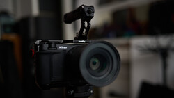 Nikon mirrorless camera with SmallRig rig mounted on top, featuring a microphone attachment and wireless receiver.