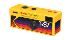 Kodak Charmera keychain digital camera from 1987 with bright yellow body and colorful striped design.
