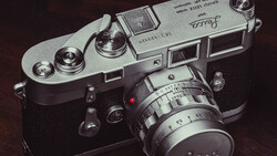Vintage rangefinder camera with chrome top plate and black body, fitted with a manual focus lens.