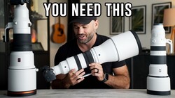 Man holding and comparing two white telephoto lenses with black accent bands at a table.