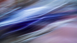 Abstract flowing light streaks in blue, white, and pink tones with motion blur effect.