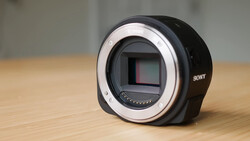 Sony mirrorless camera body without lens, showing sensor and mount ring on wooden surface.