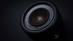 Wide-angle lens photographed from above against a dark background, showing the front glass element and barrel markings.