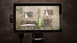 Viltrox monitor displaying waveform and focus peaking tools with live video feed on textured surface.