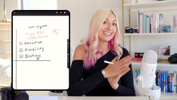 Woman with blonde and pink hair presenting a digital tablet displaying a handwritten list about high ROI priorities including attraction, visibility, and bookings.