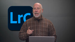 Man in brown plaid shirt speaking at podium with Lightroom logo behind him.