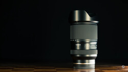 Telephoto lens mounted on wooden surface against black background.