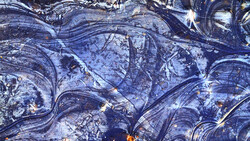 Aerial view of winding roads and water features with blue and gold tones.
