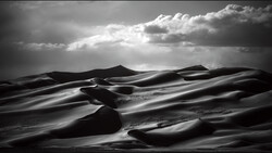 Monochromatic desert landscape with undulating sand dunes beneath dramatic clouded sky with light rays.