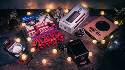 Flat lay of photography and beauty products arranged with warm string lights and decorative pinecones.