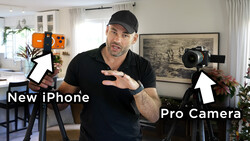 Content creator in black cap and shirt gestures between a smartphone on a tripod and a professional cinema camera, both labeled with white arrows in a bright home studio.