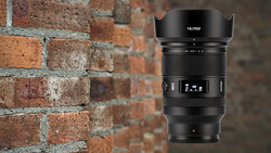 Viltrox AF 35mm f/2.8 lens with lens hood attached, displayed against a brick wall background.