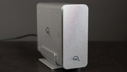 Two external hard drives with silver aluminum enclosures positioned side by side on a dark surface.