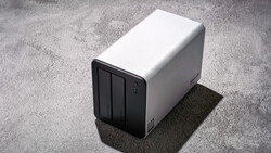 White and black desktop storage device with three compartments on concrete surface.