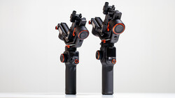Two black gimbal stabilizers with orange accents and articulated arms displayed side by side against a white background.