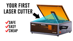 Illustration of a compact desktop laser cutter with an open orange lid and blue interior chamber.