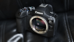 Canon EOS R6 Mark II mirrorless camera body displayed against dark fabric background.