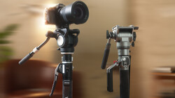Two gimbal stabilizers mounted on tripods against a blurred indoor background.