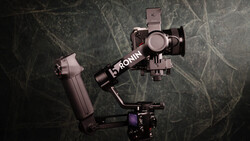 DJI Ronin gimbal with mounted smartphone stabilizer on textured dark background.