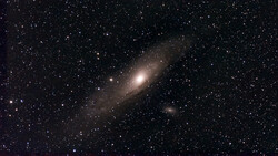 Spiral galaxy with bright central core surrounded by dust lanes and stars against dark space.