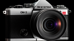 OM System OM-3 mirrorless camera with attached lens, photographed against black background.